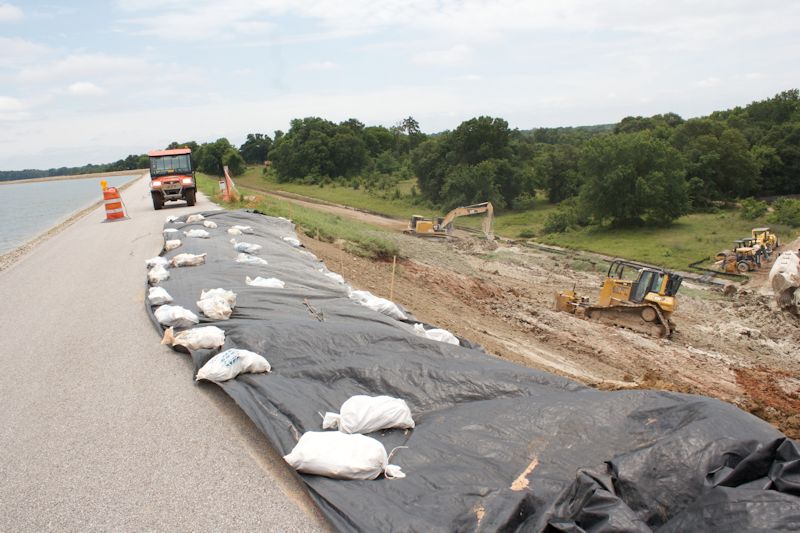 Workers are continuing to make repairs to areas where persistent heavy rains have caused the dam's soil to become saturated to the point of sloughing off.